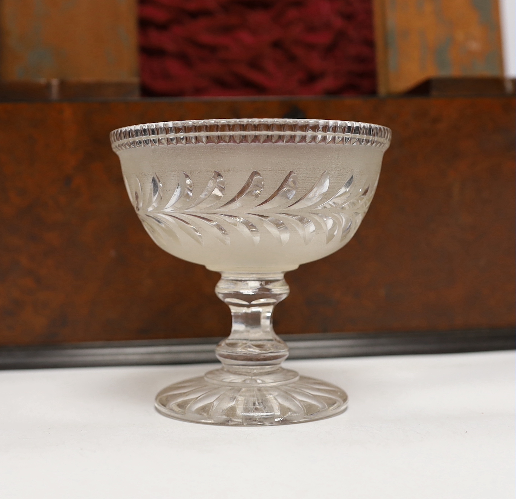 A George IV amboyna and ebony banded sarcophagus shaped tea caddy, with pedestal glass bowl, 35.5cm wide